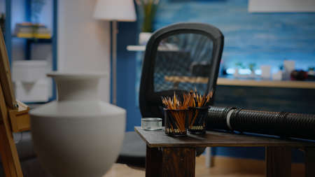 Empty artwork studio room with colorful pencils and vase for drawing occupation. Nobody in...