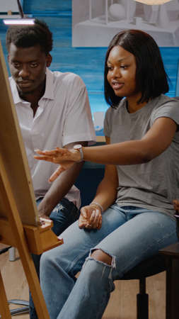 African american artists analyzing drawing of vase sitting in artwork studio room at home. Black...