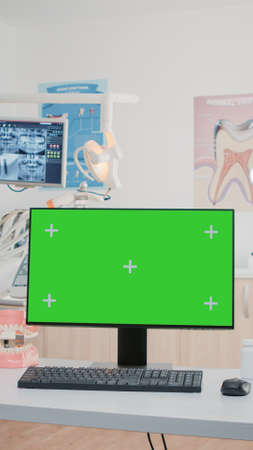 Nobody in dental cabinet with green screen on computer for teethcare. Empty dentist office with isolated background and mockup template on monitor for chroma key. Oral care and dentitionの写真素材