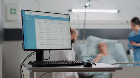 Close up of computer with information files for healthcare system. Desk with medical equipment and monitor with checkup document on screen in hospital ward. Modern display for diagnosisの写真素材