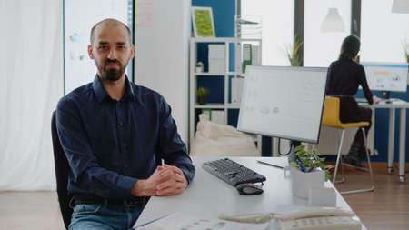 Portrait of businessman working on computer at office. Person with corporate job using monitor with...
