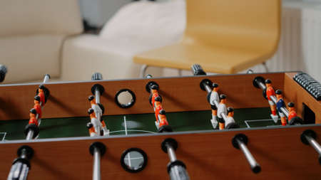 Close up of soccer game on foosball table to have fun with play after work at office. Football toy with players and ball to score goal to celebrate party with drinks after hours with colleaguesの写真素材