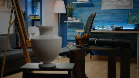 Nobody in artwork studio with creativity equipment. Empty workshop room filled with artistic drawings, craft design, white canvas and art tools for artist with imagination. Professional spaceの写真素材
