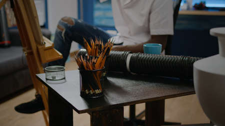 Close up of art tools on table in creative workshop studio. Artistic instruments, colorful pencils,...