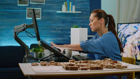 Architect using maquette for building model in office. Woman working as engineer with architectural...