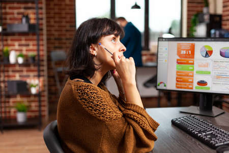 Pensive businesswoman tkinking at marketing presentation working at company strategy in startup office. Focused concentrated planning management project searching for information. Business conceptの写真素材