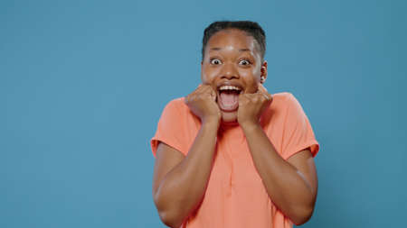 Excited woman hearing good news and feeling surprised in front of camera. Close up of amazed person...