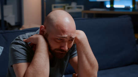 Close up of psychotic alone sad, depressed, frustrated man staring into space with tears feeling hopeless vulnerable, suffering from stress anxiety, mental problems, suicidal thoughts, chronic diseaseの写真素材
