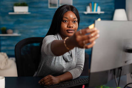 Adult putting sticky notes on monitor to work remotely. Young person using postit paper on computer...