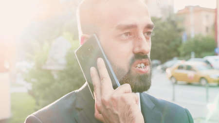 Portrait of entrepreneur man in suit talking at phone discussing management project with remote...