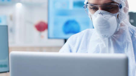 Scientist researcher with ppe equipment analyzing virus expertise typing medical diagnostic on...