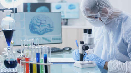 Scientist researcher doctor writing medical expertise on clipboard after analyzing blood sample during biochemistry experiment in microbiology hospital laboratory. Medicine conceptの写真素材