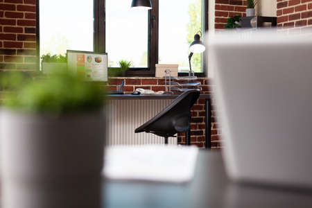 Close up of business office with computer and desk used for finance work. Nobody in empty modern space with equipment, furniture and decorations. Boardroom decor in workplace.の写真素材
