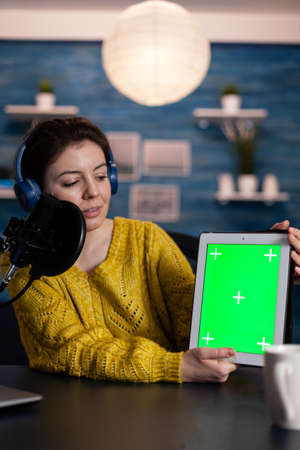 Vlogger woman recording livestream for entertainment vlog holding mock up green screen chroma key...