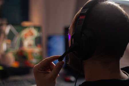 Close up of person streaming using microphone on headphones with computer. Man live streaming video...
