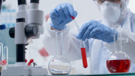 Scientist researcher doctor with ppe equipment holding test tubes analyzing blood sample working at...