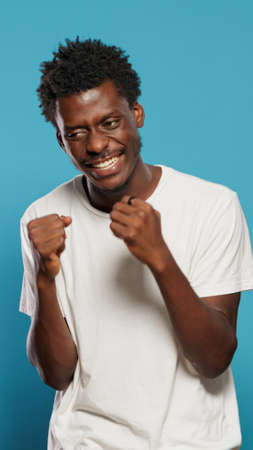 Angry man showing emotions and clenching fists in studio. Portrait of frustrated person feeling nervous and displeased while preparing for fight. Negative adult with aggressive expressionの写真素材