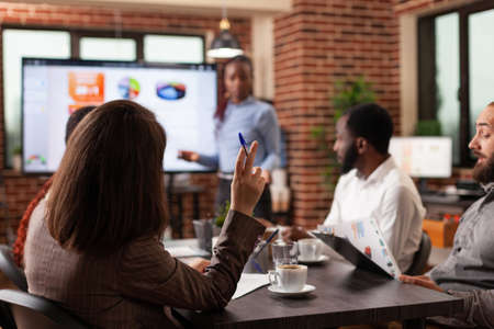 African american executive manager standing in front of monitor showing management graph discussing company strategy with team working in startup meeting office. Concept of businesspeople at workの写真素材