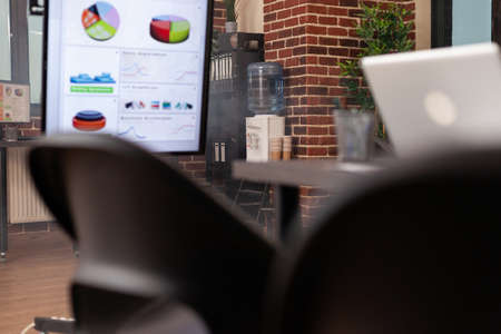 Empty start-up business office with nobody in it ready for company meeting, workplace with modern furniture having financial documents on computer desk. Concept of indoors workspaceの写真素材