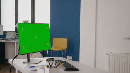 Company worker using green screen on computer at desk. Woman working with isolated mock up template and chroma key on background. Monitor with mock-up copy space on display in office.の写真素材