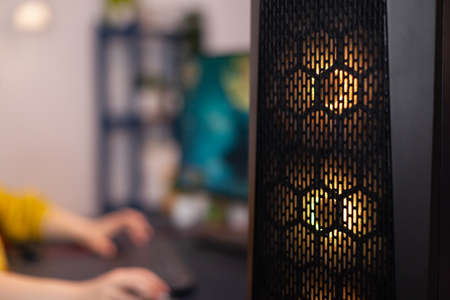 Closuep of gaming pc with rgb led lights standing on table. Gamer woman playing space shooter videogames during online competition. Studio equipped with professional streaming setupの写真素材
