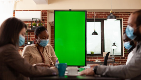 Multiethnic teamwork with medical protective face mask against coronavirus working at business...