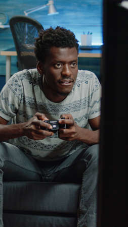 African american man losing at video games on console for fun. Black person playing online game using controller on television. Afro adult with joystick feeling irritated about lost play on tvの写真素材