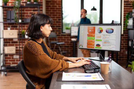 Entrepreneur looking at computer screen analyzing digital marketing graphs working at management strategy in startup office. Executive manager planning business meeting searching company solutionの写真素材