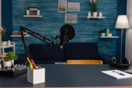 Empty home recording studio with podcast equipment. Professional microphone and headphones used for...