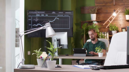 Businessman sitting at desk table in startup business office typing management strategy working at...