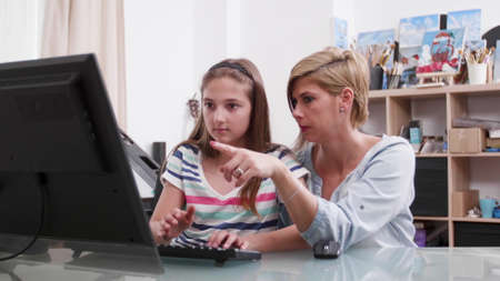 Mother helping young child with school homework explaining mathematics lesson during coronavirus...