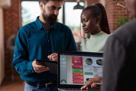Diverse businesspeople analyzing company turnover working at marketing strategy discussing business collaboration in startup office. Multi-ethnic team brainstorming ideas for projectの写真素材