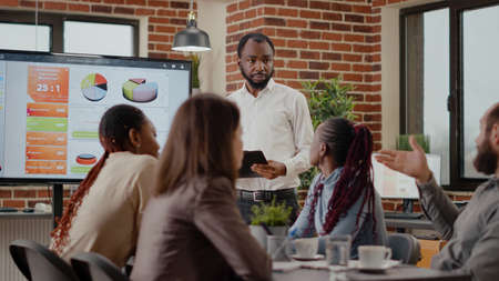 Company employee explaining charts presentation on monitor to plan project for financial development...