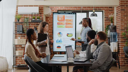 Group of coworkers meeting at business conference for presentation and project planning in startup...