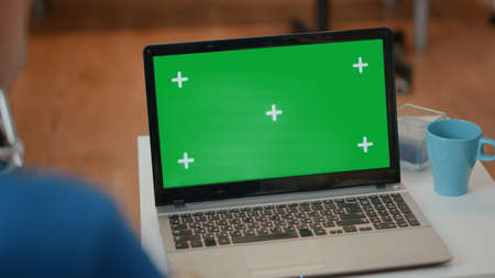 Senior man and woman looking at green screen on laptop. Elderly couple using blank copy space with isolated chroma key template and mock up background on computer. Technology on displayの写真素材