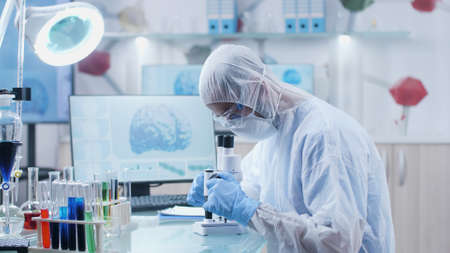 Specialist researcher doctor analyzing blood sample using medical microscope working at illness...