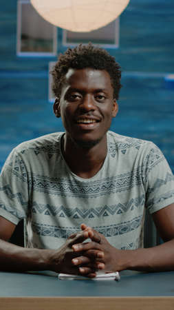 Black person talking on video call conference for remote work project with workmates. African american adult using online communication with webcam, working from home on businessの写真素材