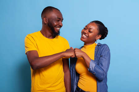 Happy partners doing fist bump gesture in agreement, celebrating achievement and teamwork. Positive...