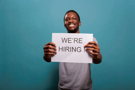 African american guy advertising hiring opportunity on paper, making job offer for human resources...