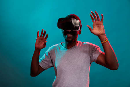 Modern adult playing with virtual reality goggle on camera, using futuristic technology to view...