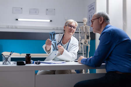 Woman doctor explaining x ray scan diagnosis to patient with illness at medical appointment....