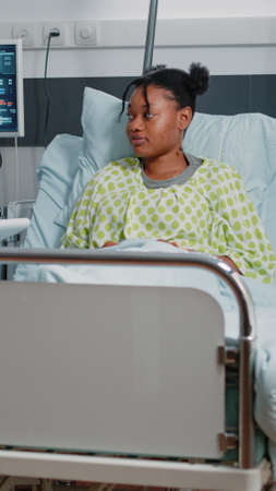 Physician doing healthcare consultation with young patient in hospital ward. Specialist talking to woman about prescription treatment and medicine to heal sickness. Medical careの写真素材