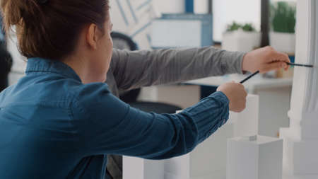 Close up of man and woman talking about maquette design, analyzing blueprints plans on table....