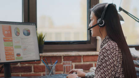 Woman consultant using headphones to chat on phone call with clients at customer service support....