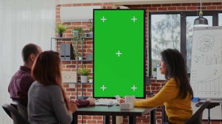 Employees using green screen on monitor vertically in boardroom, meeting to discuss ideas. Business...