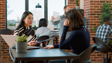 Asian worker greeting female applicant at job interview appointment to discuss work offer and career...