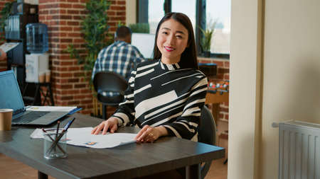 Portrait of asian HR recruiter analyzing cv resume of candidate before job interview meeting....