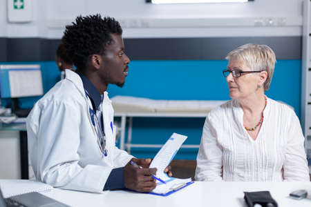 General practitioner informing ill patient of consultation results and treatment prescription. Sick...