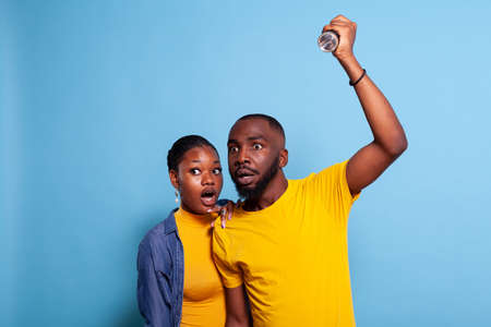Scared man and woman checking problem with flashlight, having anxious facial expression. Frightened...