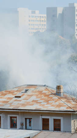 Close up of firefighters on platform truck helping with fire from burning building. Firemen with...